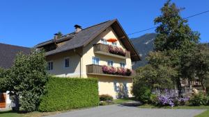 a house with flowers on the balconies of it at Ferienhaus Ball - Kometterhof in Hermagor