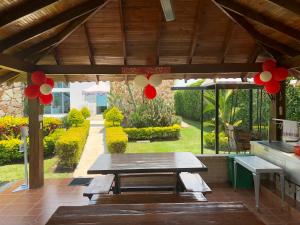 Rozo的住宿－La Morocha Hospedaje & Relax Campestre，庭院设有野餐桌和红色气球