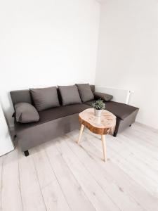 a living room with a black couch and a table at Apartament Kraków Arena in Krakow