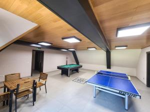 a room with a ping pong table and chairs at Băile Puturoasa in Vama
