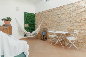 una stanza con tavolo, sedie e un muro in pietra di 20 da Vila - Messines Valley a São Bartolomeu de Messines
