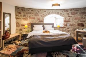 a bedroom with a bed and a stone wall at Muehlbastei-Bautzen-Turmzimmer-1 in Bautzen
