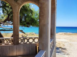 un portico con vista sulla spiaggia e sull'oceano di Casa Fronte Mare a Marina di Mancaversa