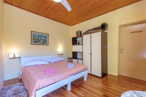 ein Schlafzimmer mit einem Bett mit einer rosa Decke in der Unterkunft Rooms Nela in Hum