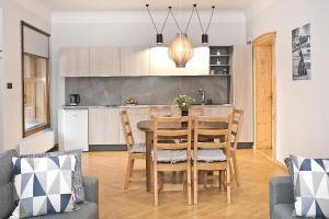 kuchnia i salon ze stołem i krzesłami w obiekcie Apartamenty Stara Apteka w Stroniu Śląskim