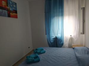 a bedroom with a bed with blue sheets and a window at Da Pinò in Vallebona