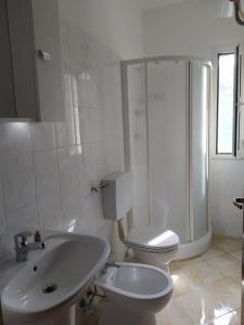 a white bathroom with a toilet and a sink at Da Pinò in Vallebona