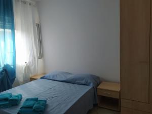 a bedroom with a bed with blue sheets and a window at Da Pinò in Vallebona