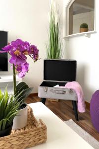 a room with a table with purple flowers and a mirror at Modern apartment in a charming old town setting in Altstätten