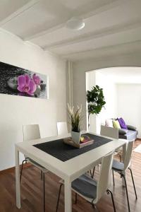 a dining room with a white table and chairs at Modern apartment in a charming old town setting in Altstätten