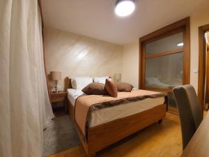 a bedroom with a bed and a large window at Apartment B331 - Aparthotel Vucko Private host in Jahorina