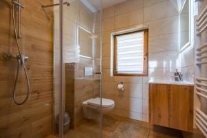 La salle de bains est pourvue de toilettes, d'une douche et d'un lavabo. dans l'établissement Domki u Skowyrów, à Gliczarów