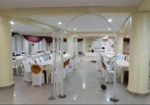 a dining room with white tables and white chairs at Presken Hotels @Alade Avenue in Ikeja