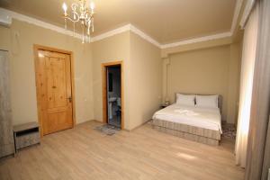 een grote slaapkamer met een bed en een kroonluchter bij Hotel Shogi in Zugdidi
