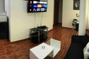 uma sala de estar com um sofá, uma mesa e uma televisão em 200. Hermoso Departamento con Servicios Incluidos en Chorrillos em Lima