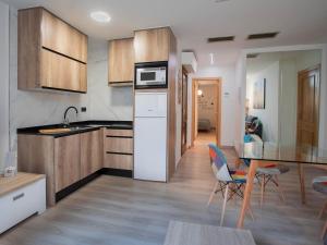 サラゴサにあるApartamentos El Pilarのキッチン(木製キャビネット、テーブル、椅子付) +21枚の写真