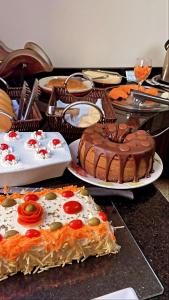 una mesa con varios platos de comida y un pastel de chocolate en Hotel Desbravador, en Chapecó