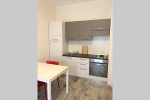 a kitchen with white cabinets and a white table at La Cascinetta - BGY Airport in Grassobbio