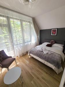 1 dormitorio con cama, sofá y mesa en Băile Puturoasa, en Vama