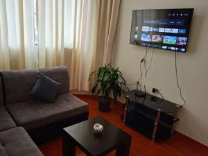sala de estar con sofá y TV en la pared en 201 Departamento exclusivo en Chorrillos, en Lima