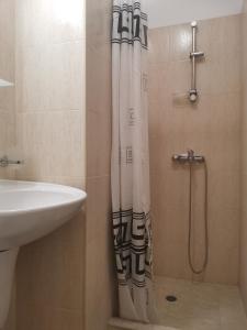 a bathroom with a shower curtain and a sink at Studio in Murphys Lodge in Bansko