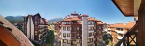 a group of buildings in a city with mountains at Studio in Murphys Lodge in Bansko