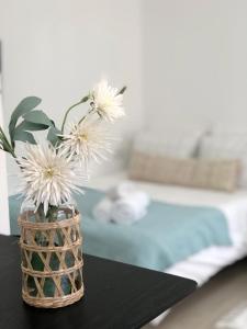 a vase with white flowers on a table in a bedroom at Oria studio's in Eilat