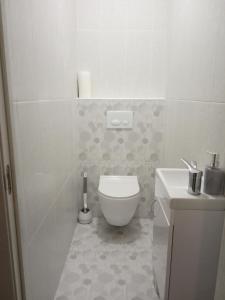 biała łazienka z toaletą i umywalką w obiekcie Modern fresh-new appartment near the park Sofievka w mieście Humań