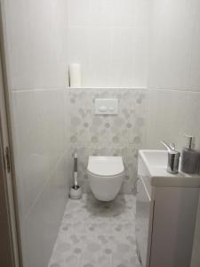 a white bathroom with a toilet and a sink at Modern fresh-new appartment near the park Sofievka in Uman