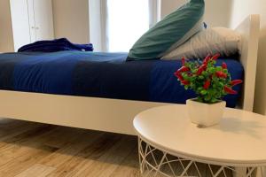 ein Bett mit einer blauen Decke und einem Tisch mit Blumen in der Unterkunft BGY Airport - La Cascinetta in Grassobbio