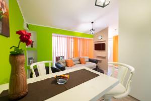 een woonkamer met groene muren en een tafel en een bank bij Downtown 1 in Subotica