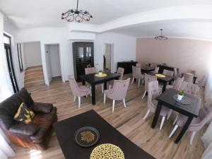 a living room with tables and chairs and a dining room at Băile Puturoasa in Vama