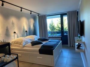 a bedroom with a large bed with a large window at Schwarzwald Wohnung Kniebis in Freudenstadt