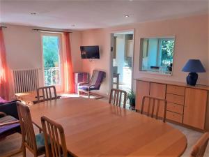 comedor con mesa de madera y sillas en la siestou, en Le Monteil