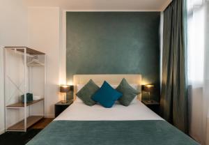 - une chambre avec un lit doté d'oreillers bleus et verts dans l'établissement Heart Milan Apartments Duomo Terrace, à Milan