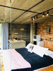 ein Schlafzimmer mit einem Bett in einem Zimmer mit einer Küche in der Unterkunft Cabana Efatah - Pousada Colina dos Ventos in Urubici