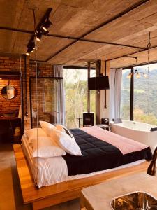 um quarto com uma cama grande e uma banheira em Cabana Efatah - Pousada Colina dos Ventos em Urubici