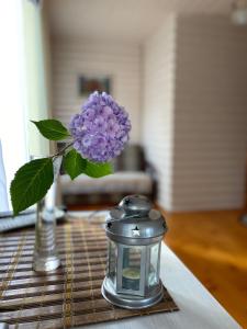 a vase with a purple flower and a lantern on a table at Karpatska Mria in Yaremche