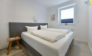 A bed or beds in a room at Haus Kiek in't Watt - Ferienwohnung Lieselotte