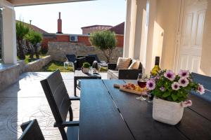 ラザナッツにあるHoliday House VENTUMのパティオにワイングラスと花が置かれたテーブル +38枚の写真