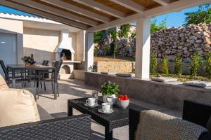 ラザナッツにあるHoliday House VENTUMの石壁のパティオ(テーブル、椅子付)