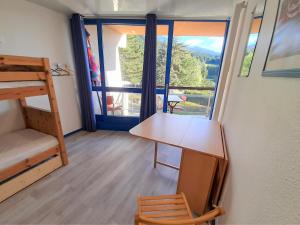 a room with a bunk bed and a desk and a window at Un air de Bretagne à la montagne-STUDIO AVEC BALCON in Villard-de-Lans