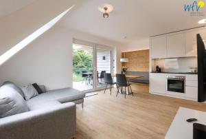 a living room with a couch and a kitchen at Haus Talita - Wohnung ZULU in Juist