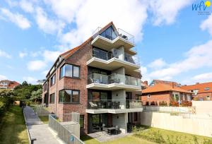 a tall brick building with a balcony on top of it at Haus Talita - Wohnung ALFA in Juist +7 photos