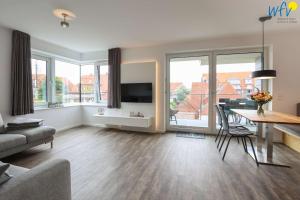 a living room with a table and a dining room at Haus Talita - Wohnung LIMA in Juist