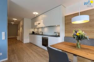 a kitchen with a wooden table and a vase of flowers at Haus Talita - Wohnung GOLF in Juist