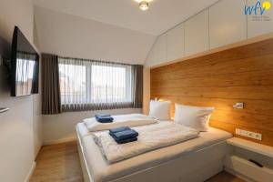 a bedroom with a bed with two blue towels on it at Haus Talita - Wohnung GOLF in Juist