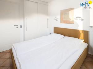 a bed in a room with white walls at Haus Ebbe und Flut A - Ferienwohnung Deichläufer in Juist
