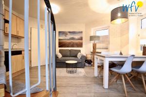 a kitchen and living room with a table and a couch at Haus Solaris - Ferienwohnung D'runner un D'rover in Wangerooge +16 photos