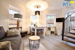 a living room with a couch and a table at Haus Solaris - Ferienwohnung D'runner un D'rover in Wangerooge